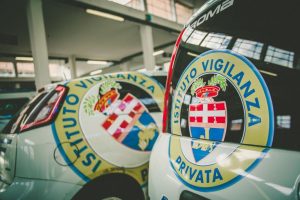 Auto con logo "Istituto Vigilanza Privata" in garage.