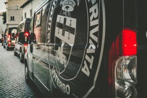 Furgoni con logo di istituto di vigilanza in strada.