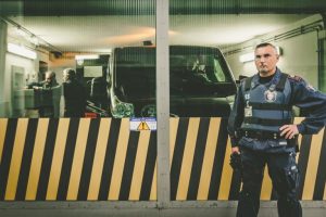 Guardia di sicurezza davanti a furgone blindato in garage.