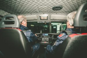 Due persone in uniforme guidano un veicolo di emergenza.