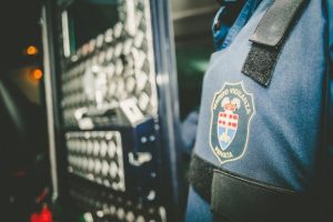 Guardia di sicurezza con uniforme e stemma visibile.