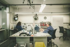 Due persone lavorano in un laboratorio con attrezzature elettroniche.