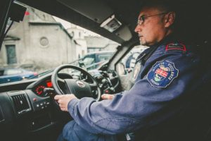 Guardia giurata guida un veicolo blindato.