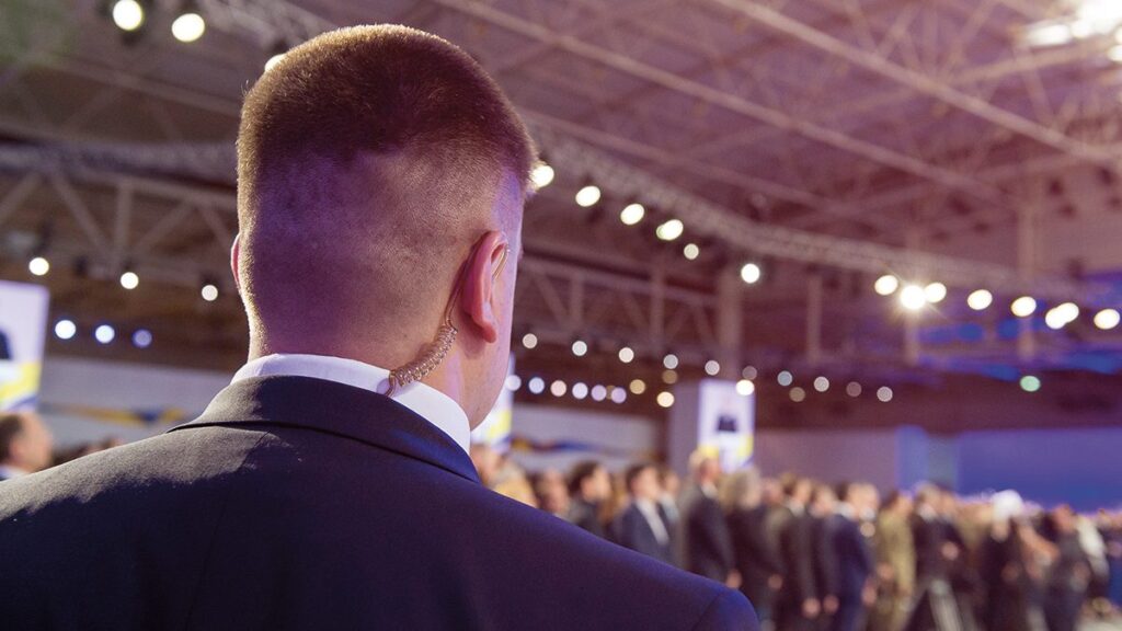 Persona con auricolare in un evento affollato.
